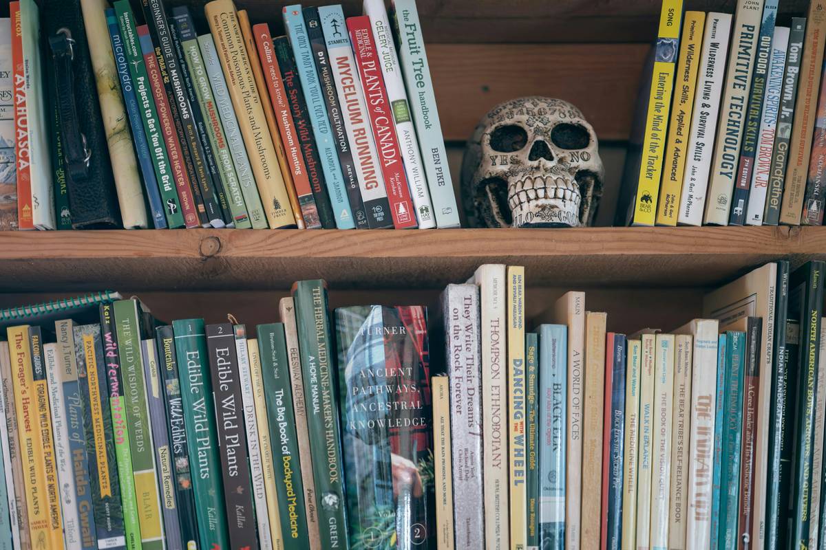 Stack of authentic psychological horror books arranged on a dimly lit desk with shadowy ambiance